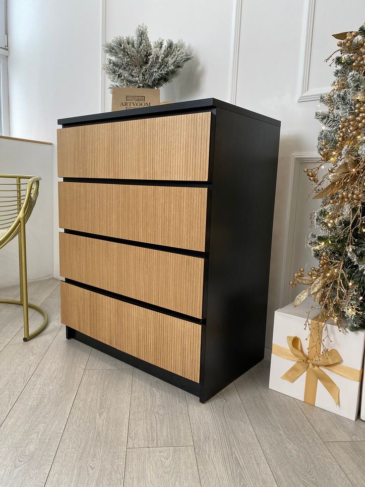 a wooden dresser sitting next to a christmas tree