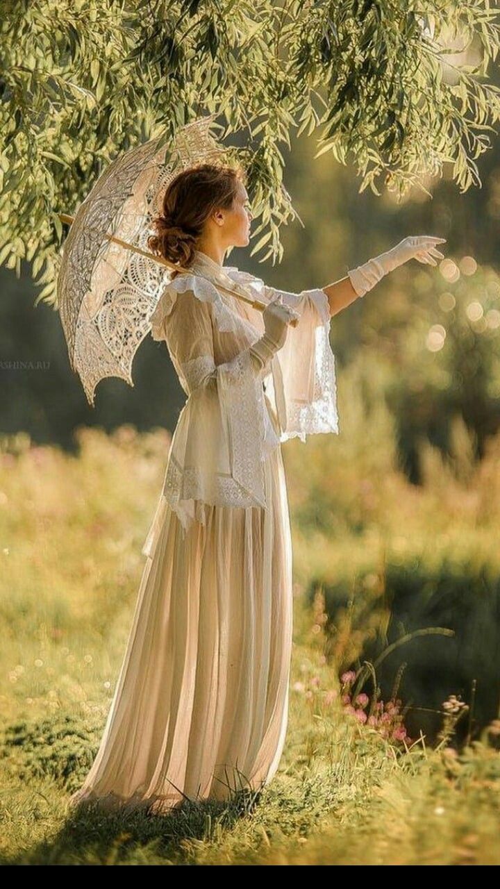 a woman holding an umbrella under a tree