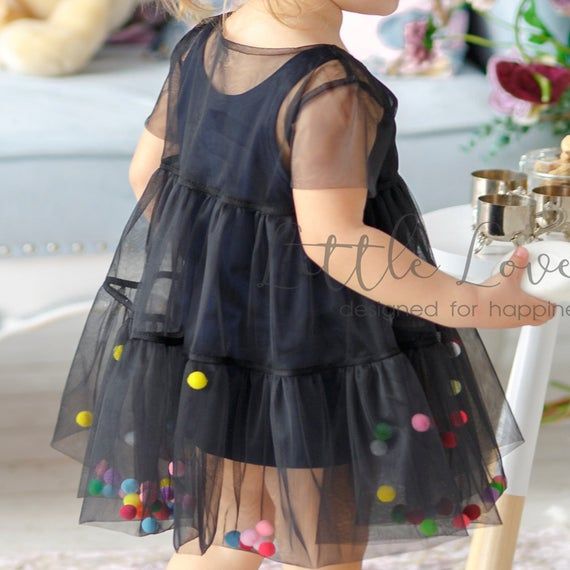 This layered tulle dress with fluttering flounces is a synonym to airness and tenderness in which your baby girl will look impressive! Dozens of candy-colored pom-poms will catch the eye on this fairy outfit and give it a little bit more sweetness! The lower layer plain dress is made of 80% cotton and 20% elastane and the upper is made of delicate soft tulle for best comfort!Pom-poms are not sewn inside for lightness! The color of pom-poms can be changed upon request! If you have your own idea a Black Dress Kids, Tulle Baby Dress, Black Tulle Dress, Girls Tulle Dress, Kids Dress Wear, 파티 드레스, Girl Dress Patterns