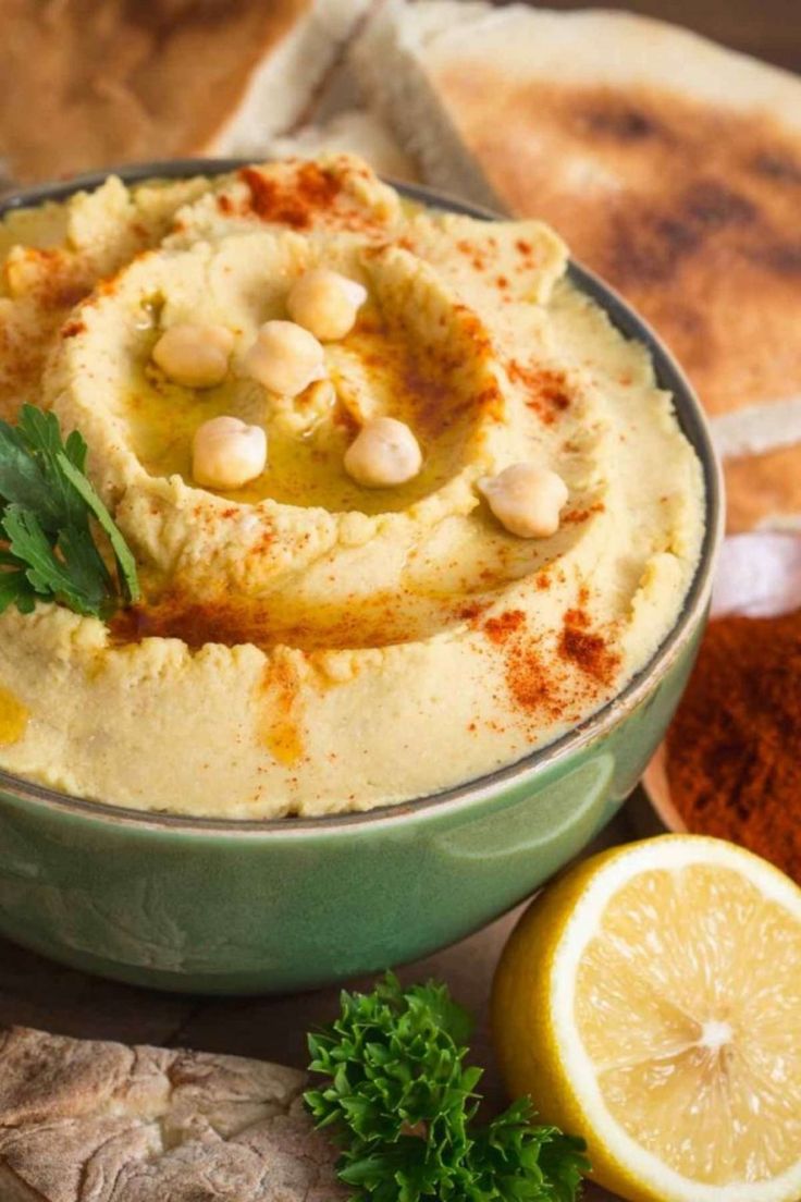 hummus in a bowl with garlic, lemon and parsley