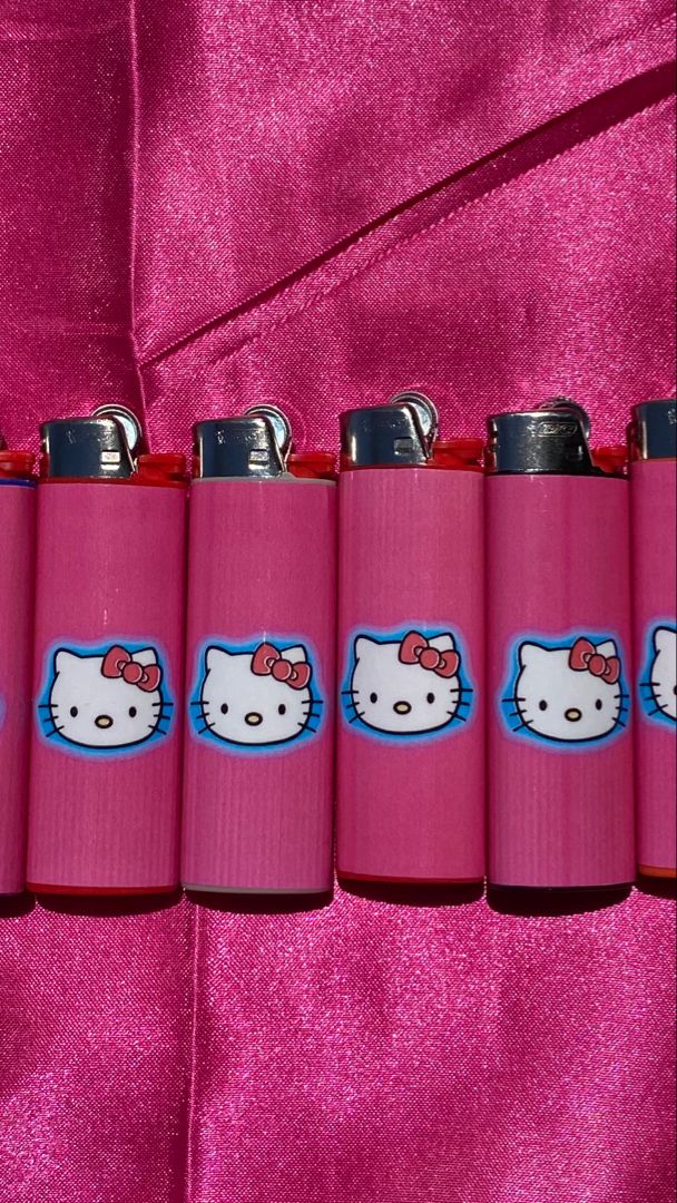 hello kitty lighters lined up on a pink cloth