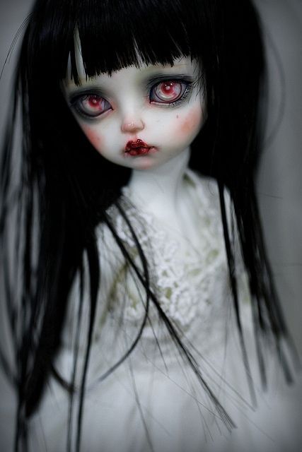 a creepy doll with long black hair and red eyes