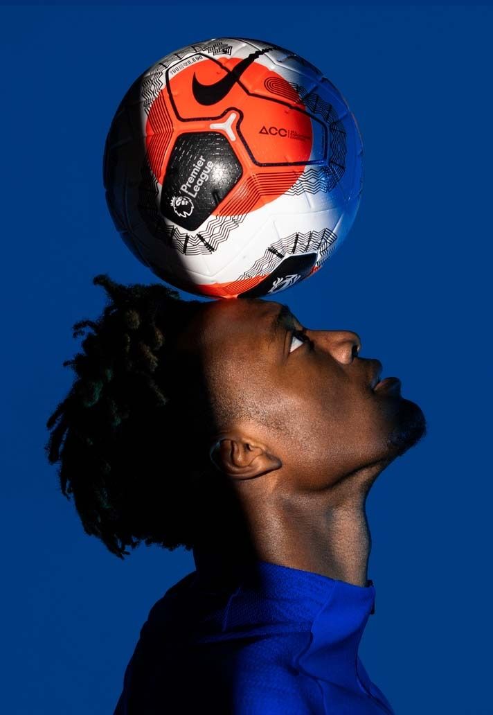 a woman with her head on top of a soccer ball in the air above her head