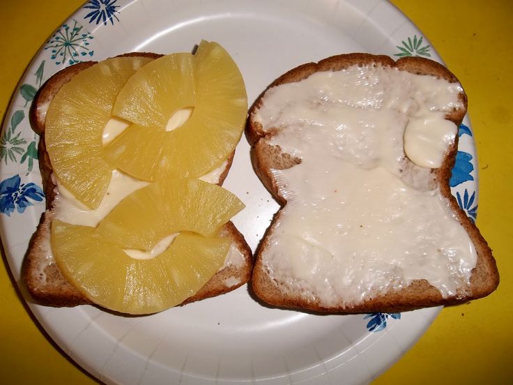 two pieces of bread on a plate with cheese and orange slices next to each other