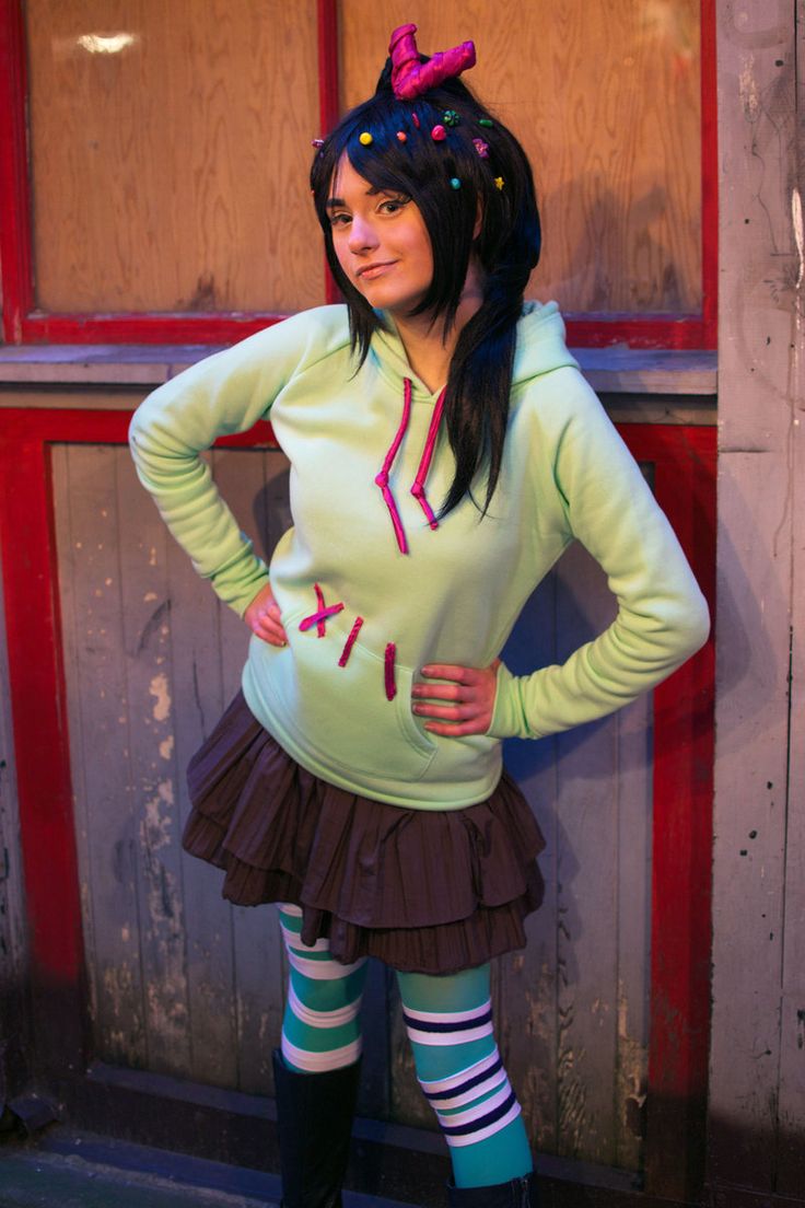 a woman in a green shirt and skirt posing for the camera with her hands on her hips