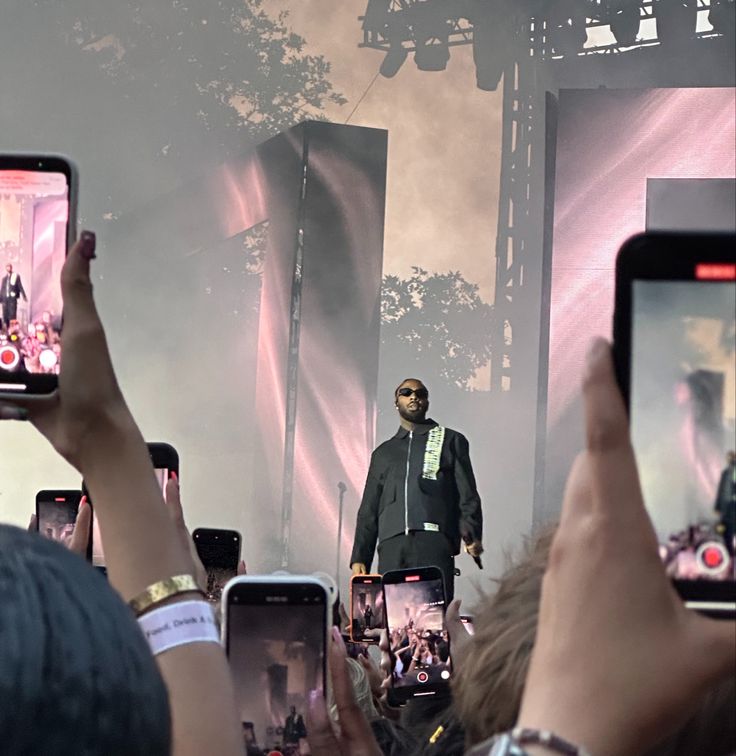 a group of people holding up their cell phones in front of a man on stage