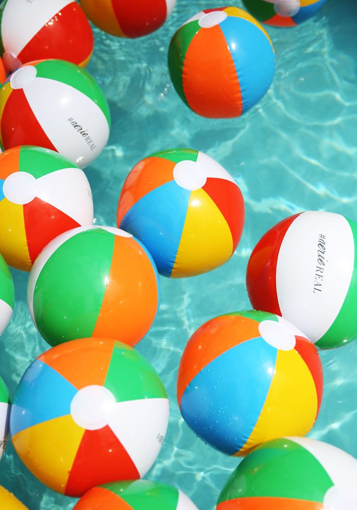 many colorful beach balls floating in the water