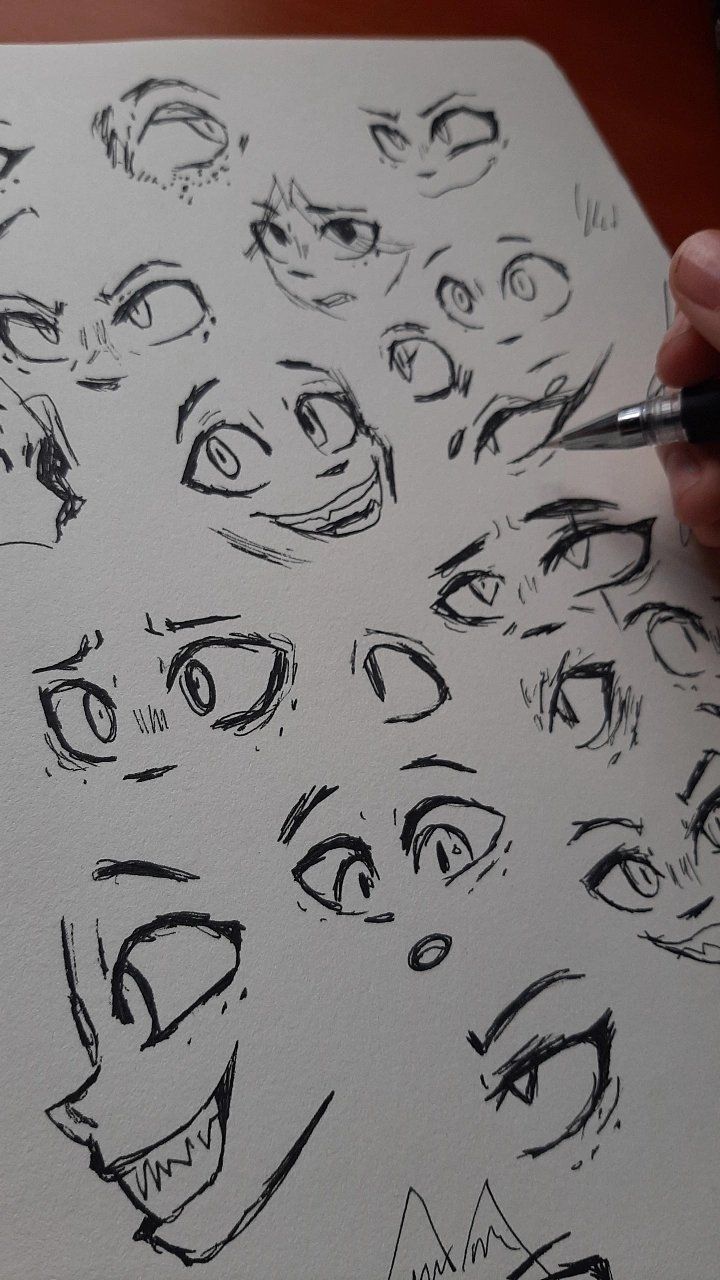 someone is drawing faces on a piece of paper with a pen and inking it