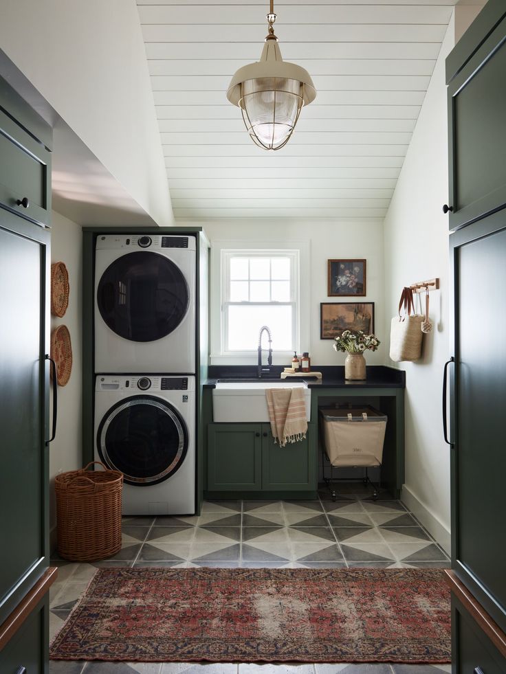 a washer and dryer sitting in a kitchen next to each other on top of a rug