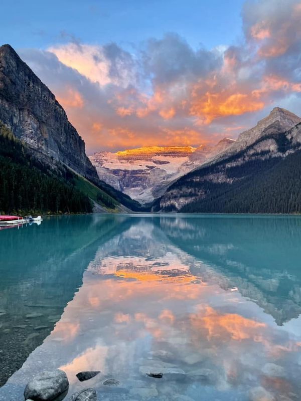 the mountains are reflected in the water at sunset