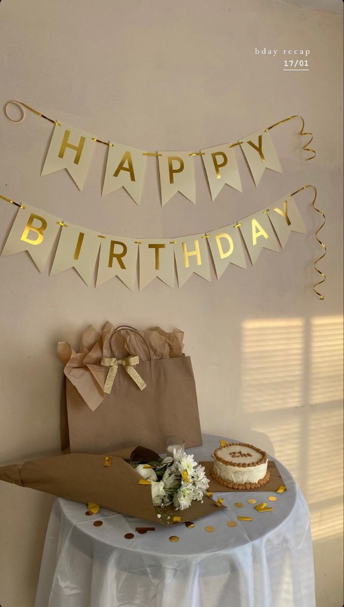 a birthday cake on a table with gold confetti and streamers around it