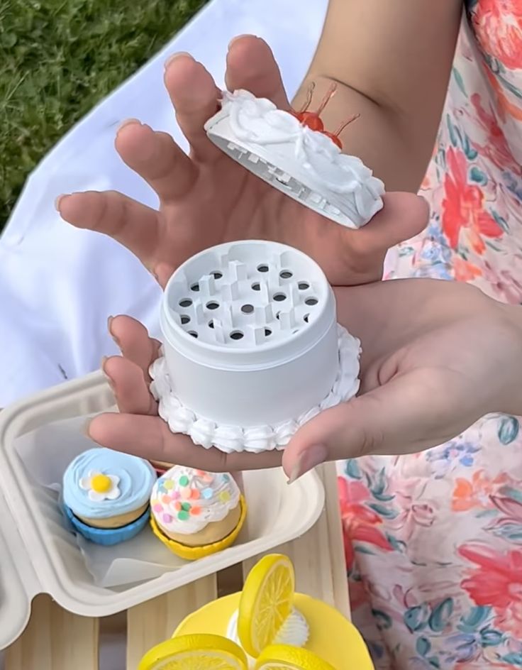 a woman is holding out her hand with cupcakes and lemons in it