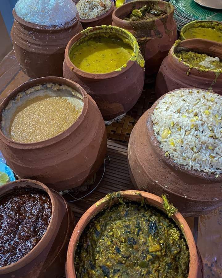 several clay pots filled with different types of food