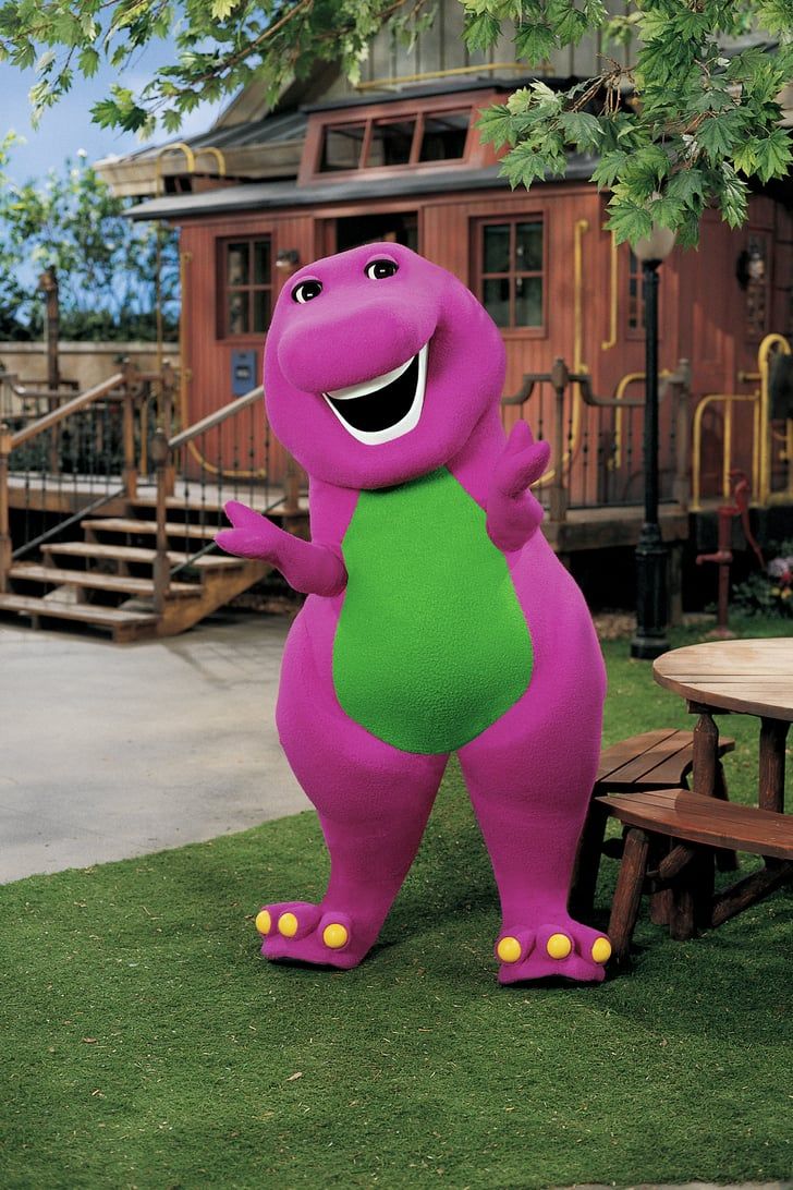 a large purple dinosaur standing next to a picnic table