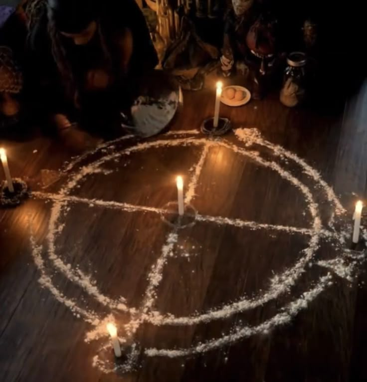 people sitting around a table with candles in the shape of a peace sign on it