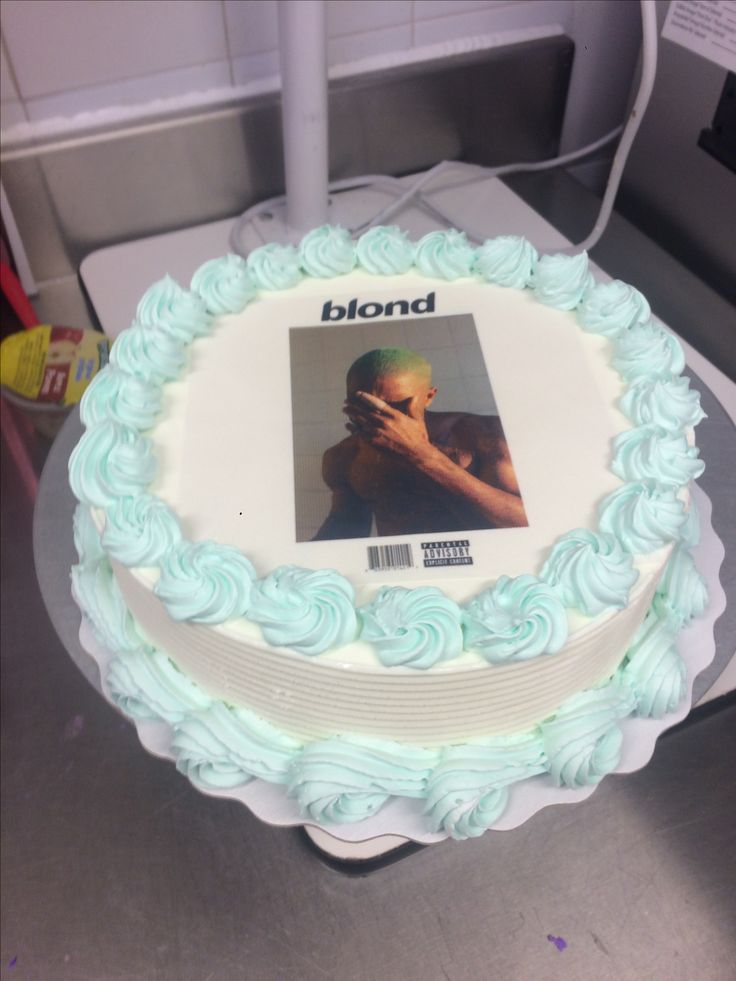 a white cake with blue frosting and a photo on it