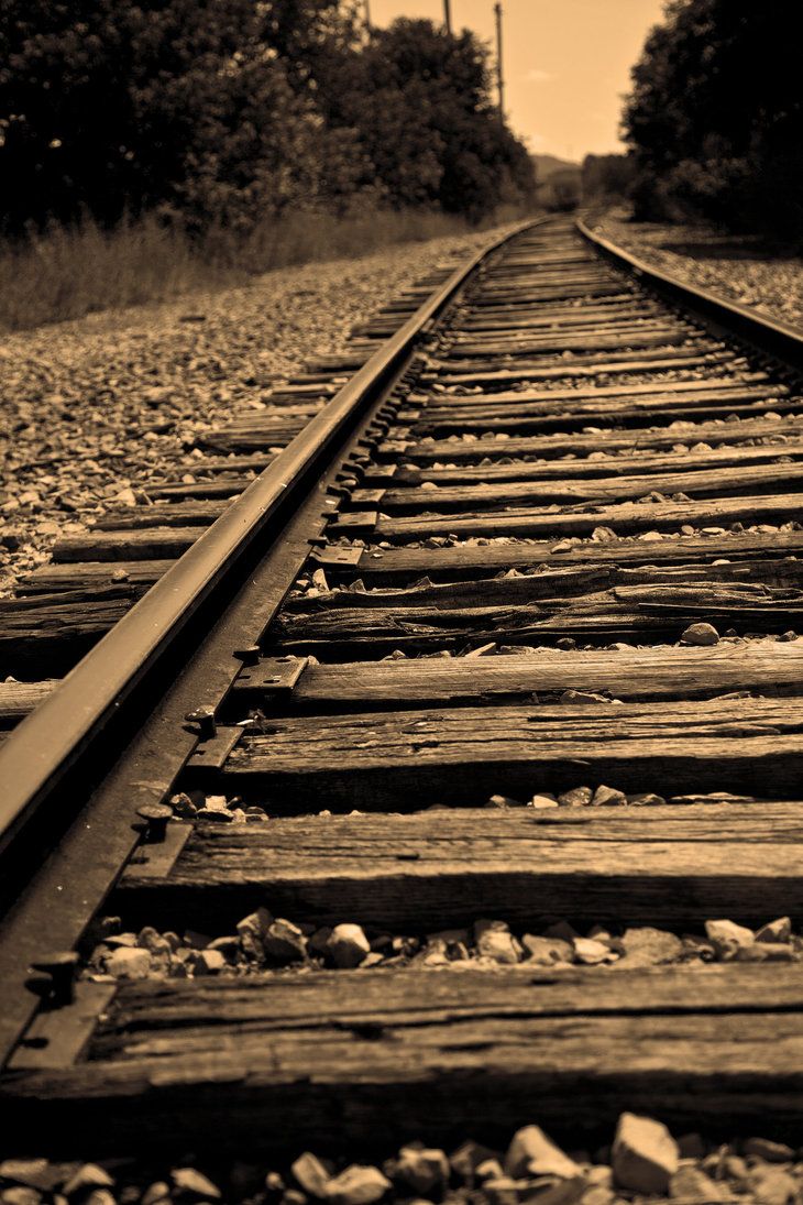 an old train track with trees in the background