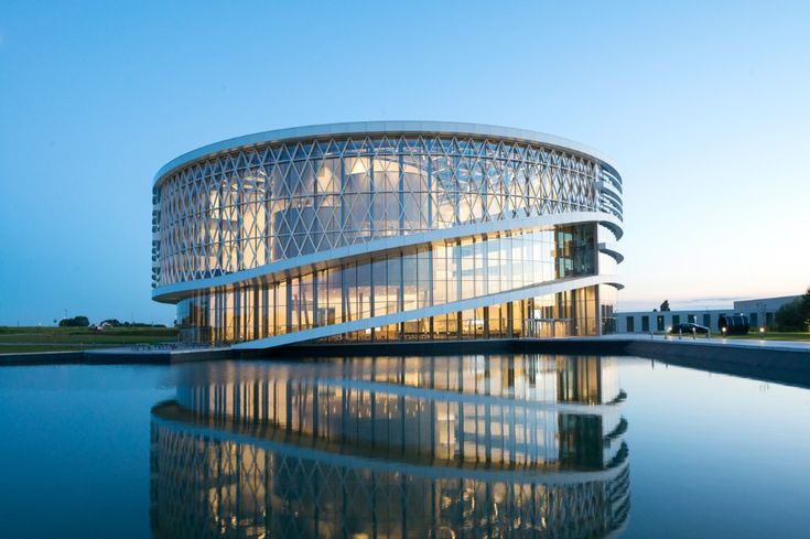 a large building that is next to a body of water with its reflection in the water