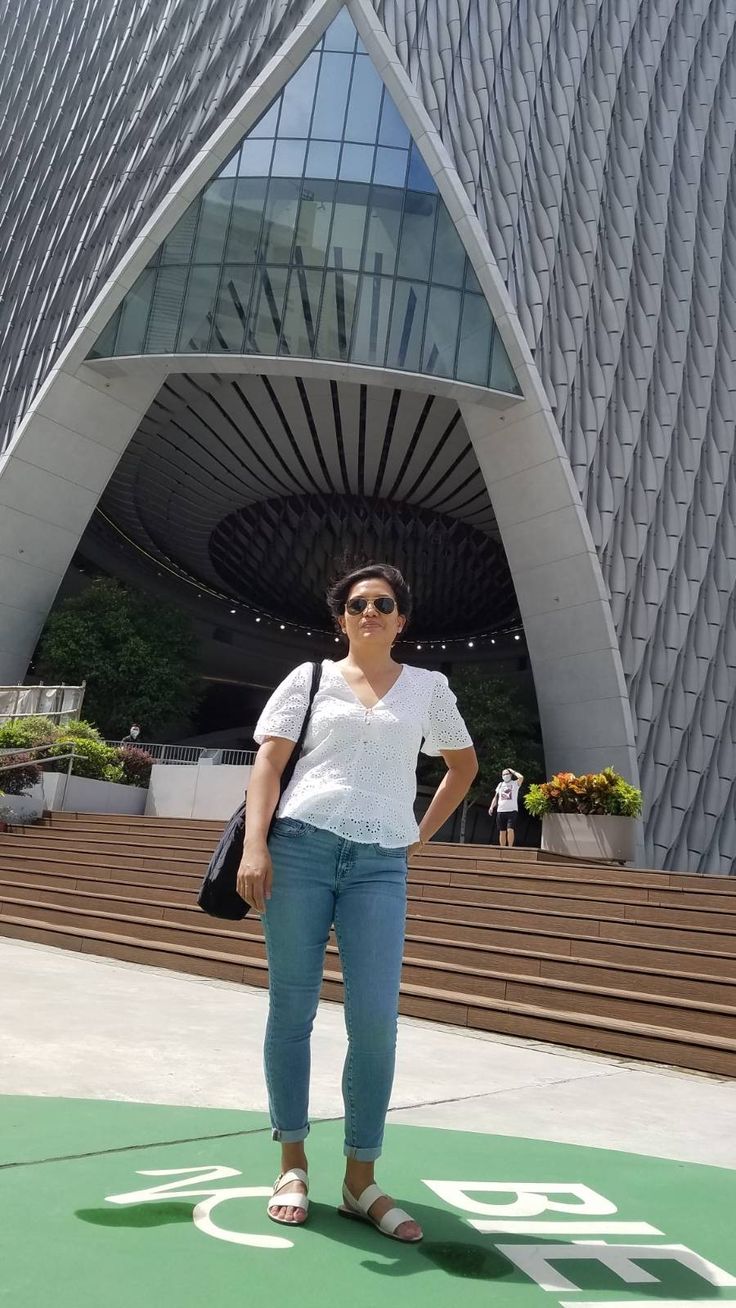 a woman standing in front of a large building