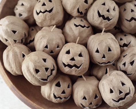 a bowl filled with carved pumpkins sitting on top of a table