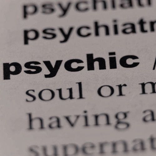 the word psychic is highlighted in an open book with black and white text on it