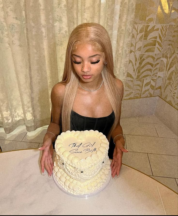 a woman sitting at a table with a cake in front of her