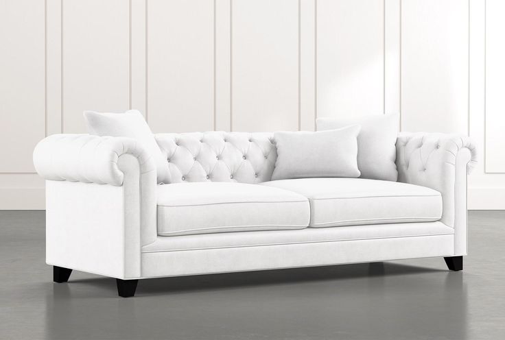 a white couch sitting on top of a hard wood floor