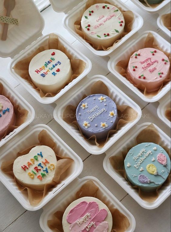 many cupcakes are decorated with icing and sprinkles in small trays