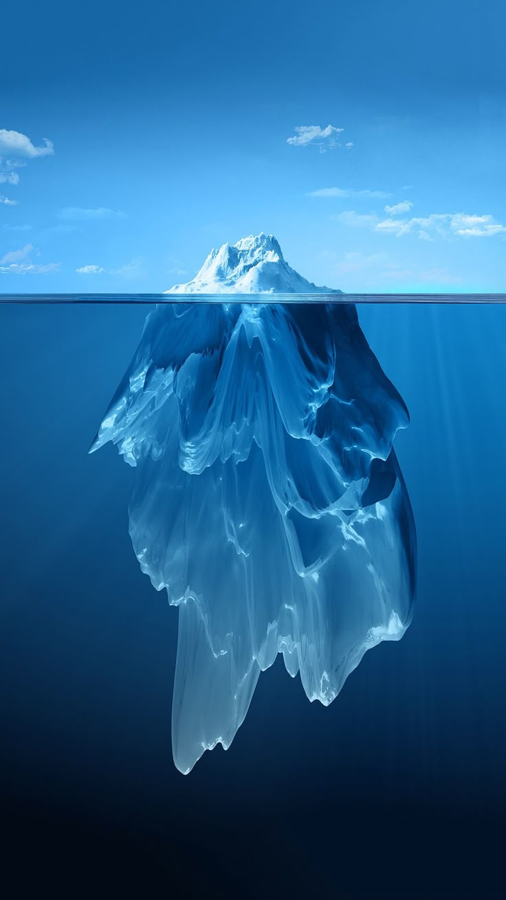 an iceberg floating in the ocean with blue sky and clouds above it, under water