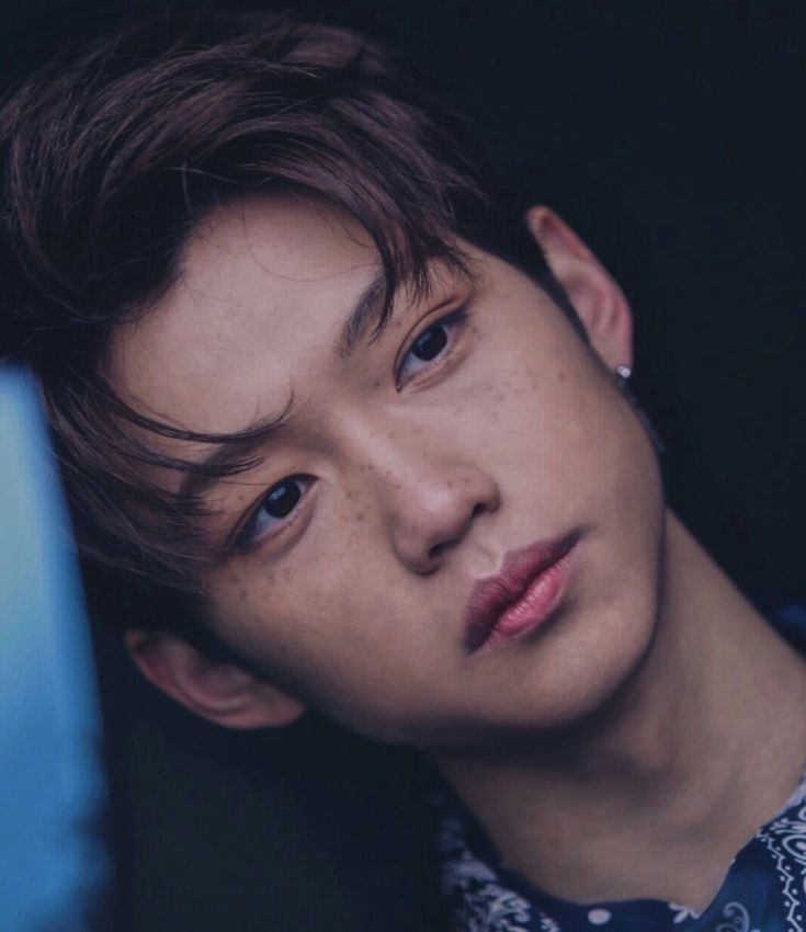 a young man wearing a shirt and tie looking at the camera with an intense look on his face