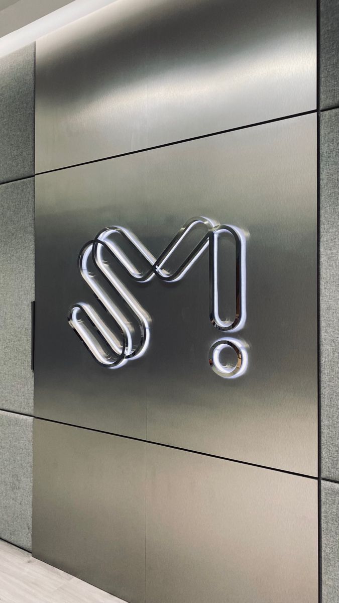 the entrance to an office building with a shiny metal sign