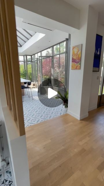 an empty living room with wood floors and large windows