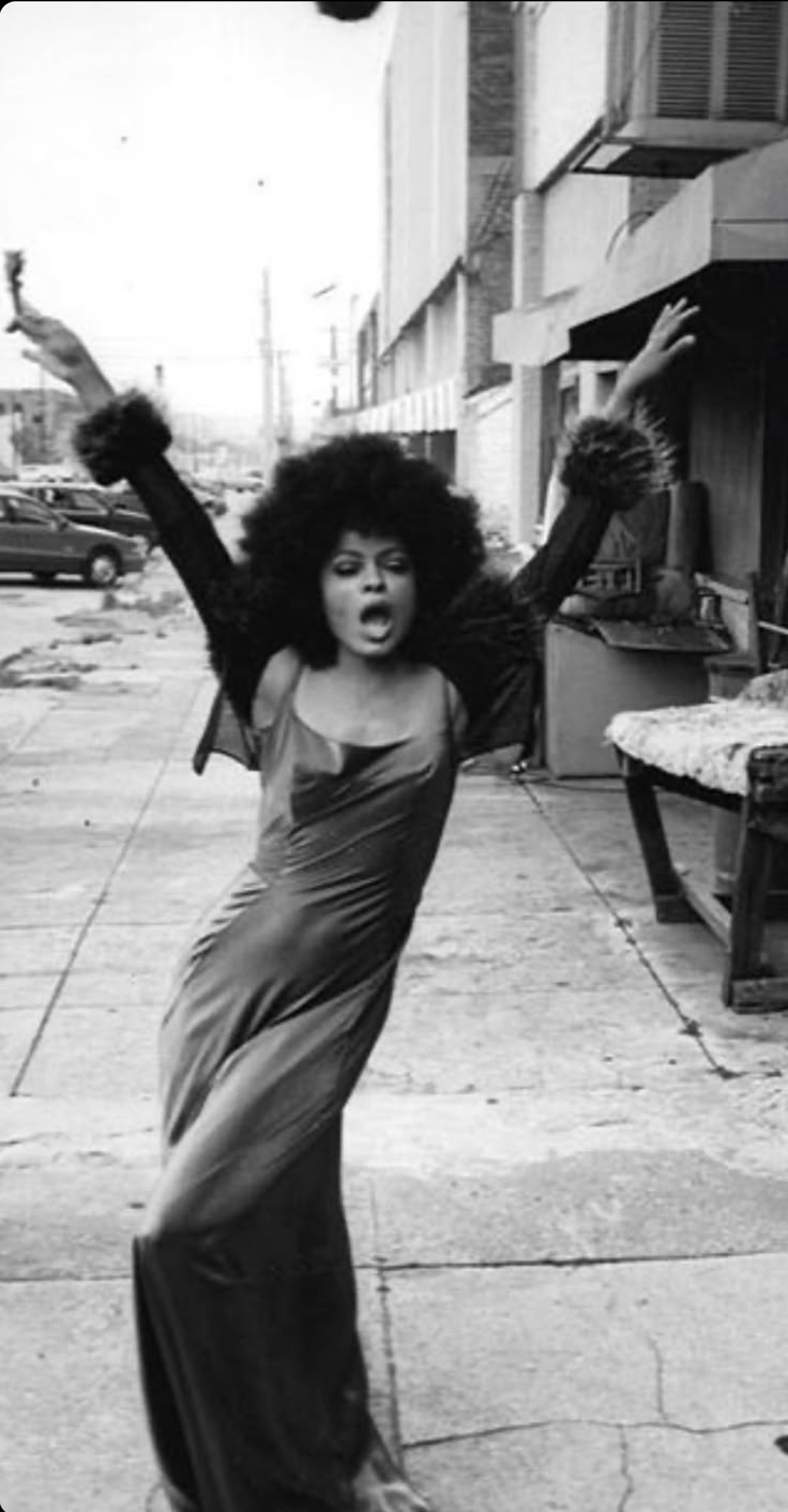 an old photo of a woman dancing on the sidewalk