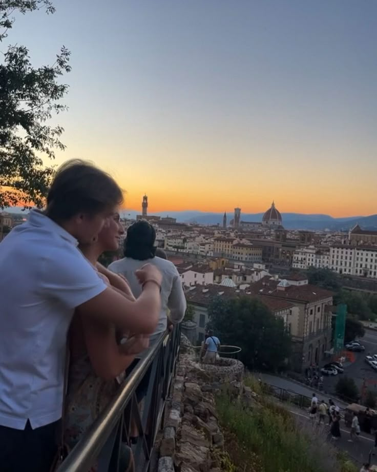 two people looking out over the city at sunset