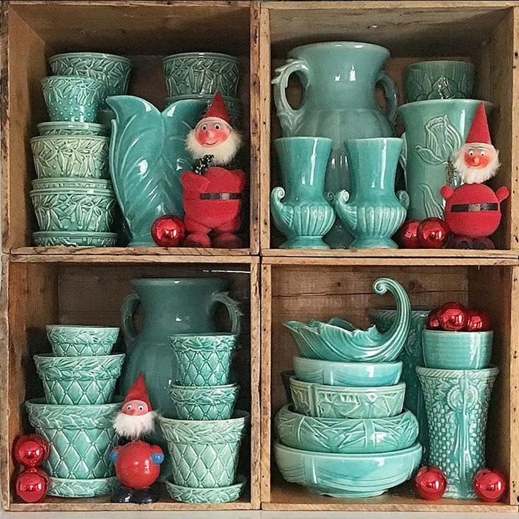 a wooden box filled with lots of green vases and other decorative items on top of it