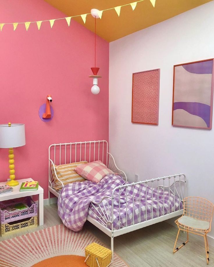 a bedroom with pink walls and white furniture