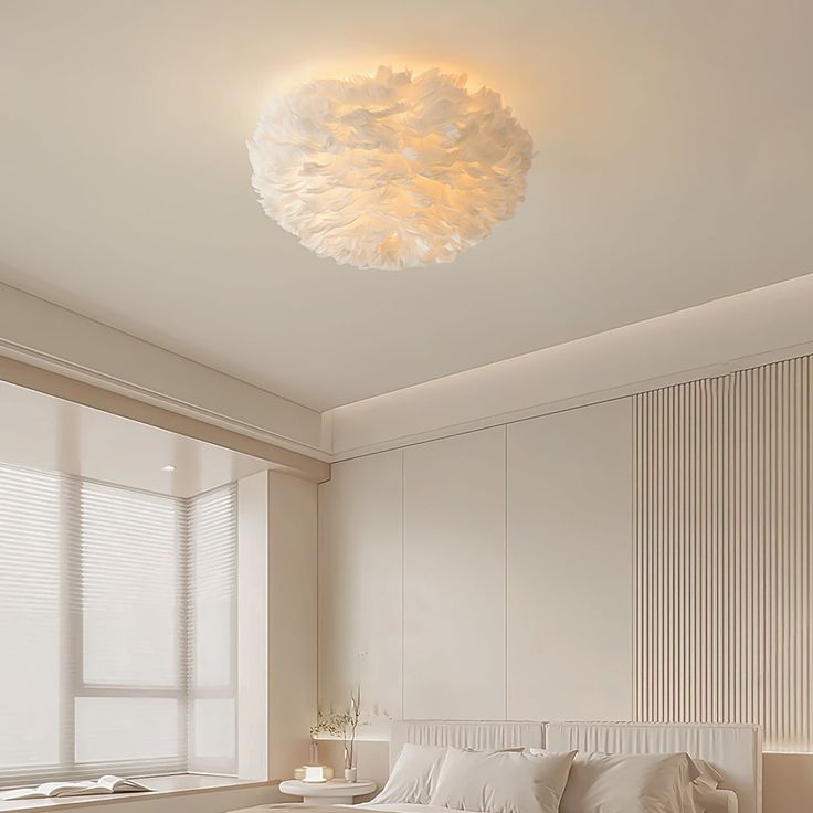 a white bed sitting under a round light fixture in a bedroom next to a window