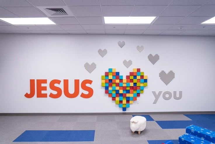 a sheep is standing in front of a wall that says jesus you