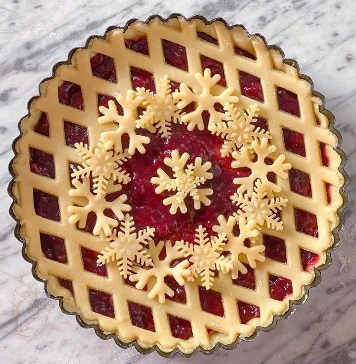 a pie with snowflakes on it sitting on top of a marble countertop