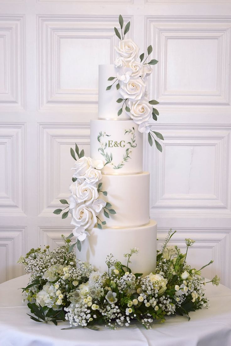 a wedding cake with white flowers and greenery