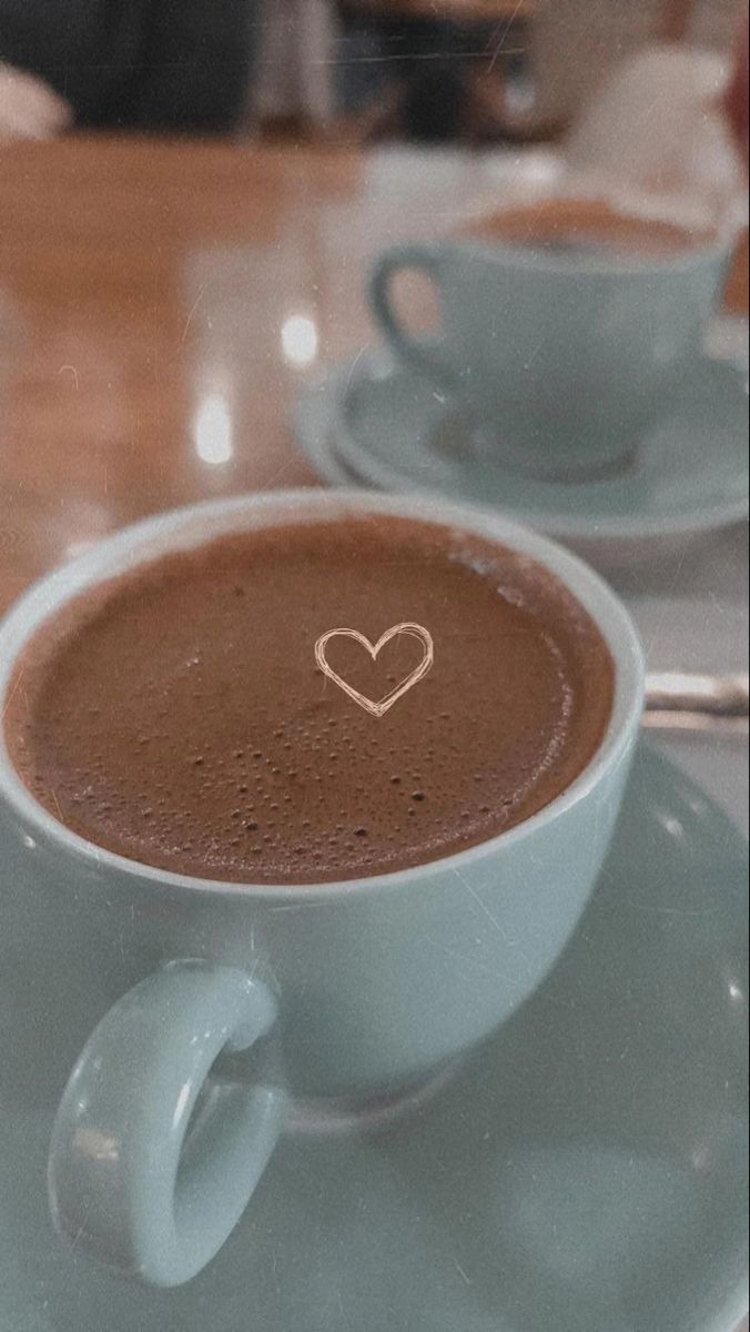 two cups of hot chocolate with a heart drawn on the top