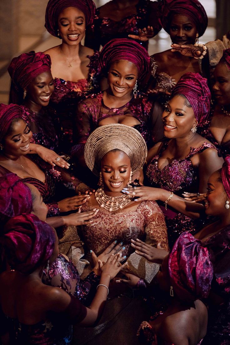 a group of women standing next to each other in purple dresses and turbans