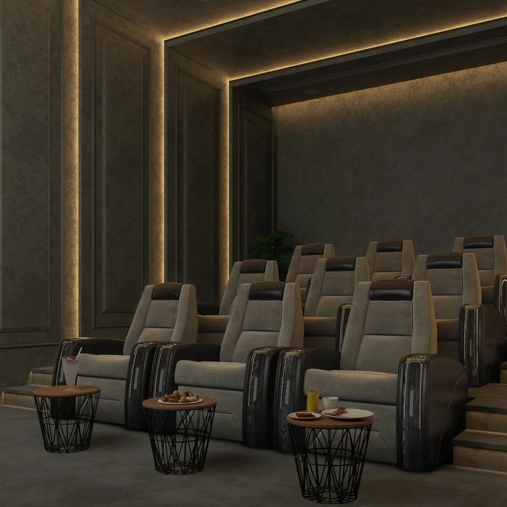 an empty movie theater with chairs and tables on the floor, in front of a row of seats