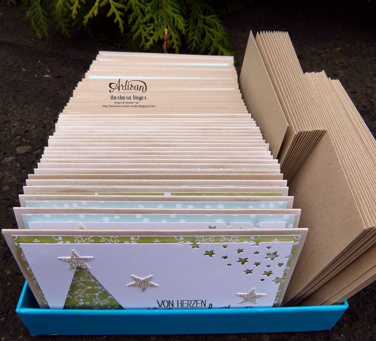 a blue box filled with lots of cards next to a christmas tree on the ground