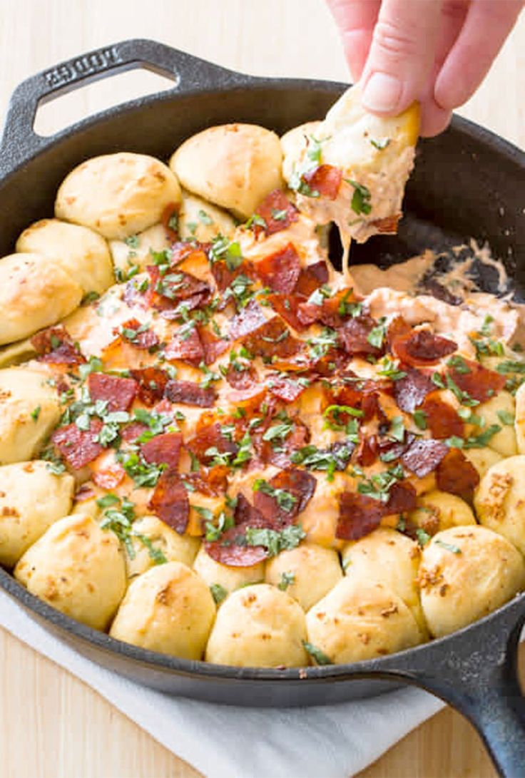 a person dipping some food into a skillet