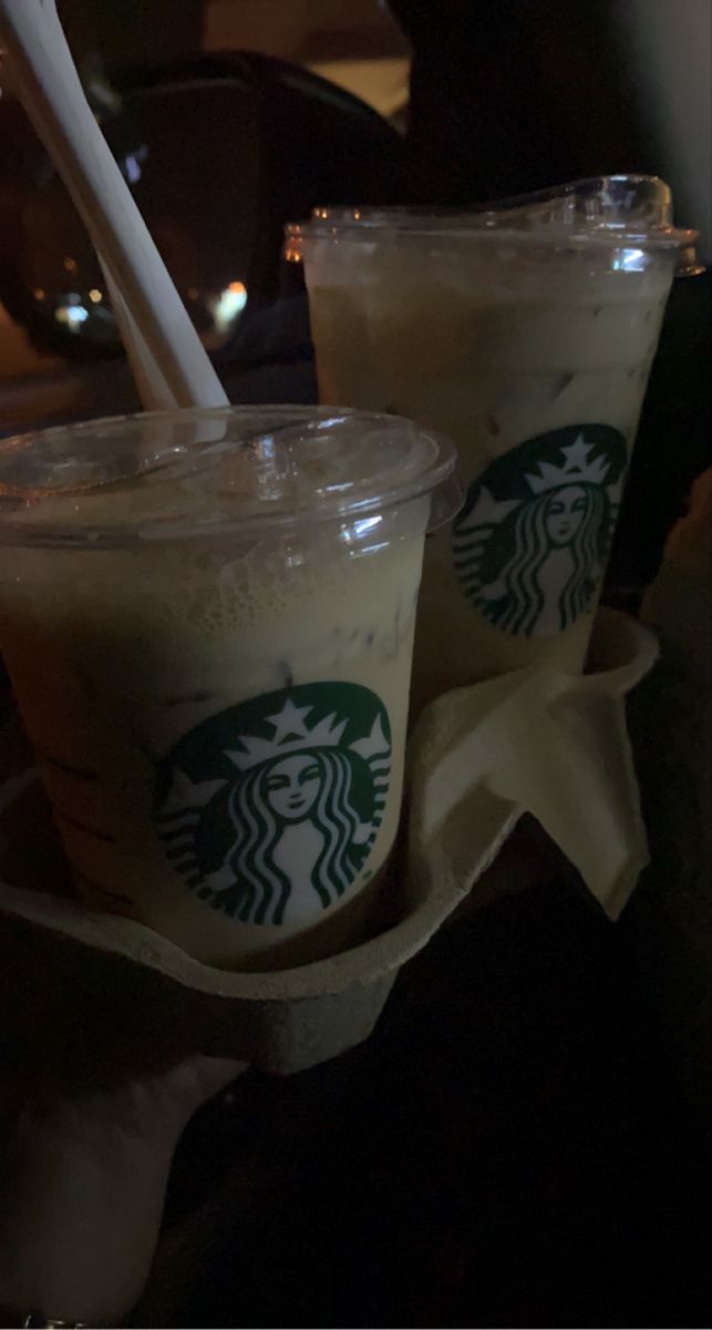 two starbucks drinks with straws in plastic cups