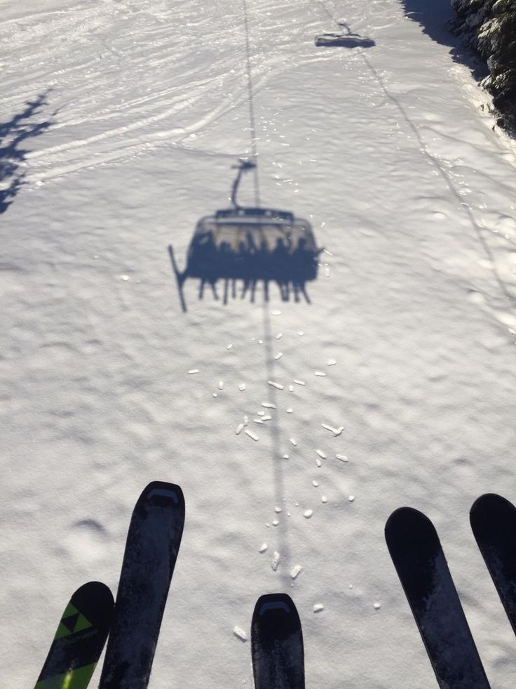 the ski lift is going down the snowy hill with snow on it's sides