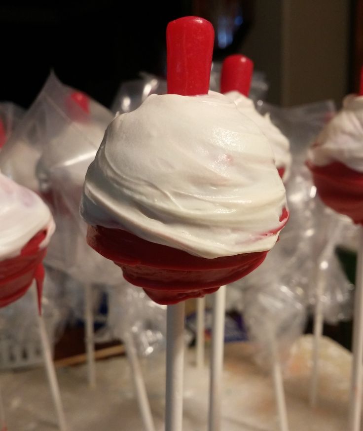 some red and white cake pops with icing on them are ready to be eaten