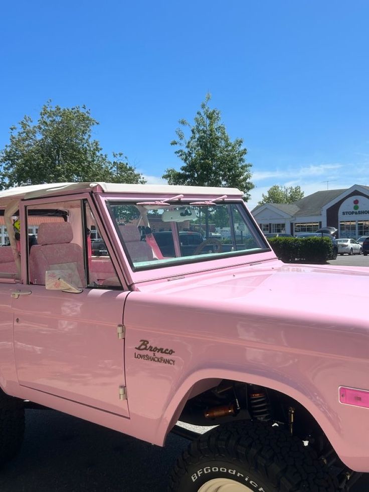 a pink pick up truck parked in a parking lot