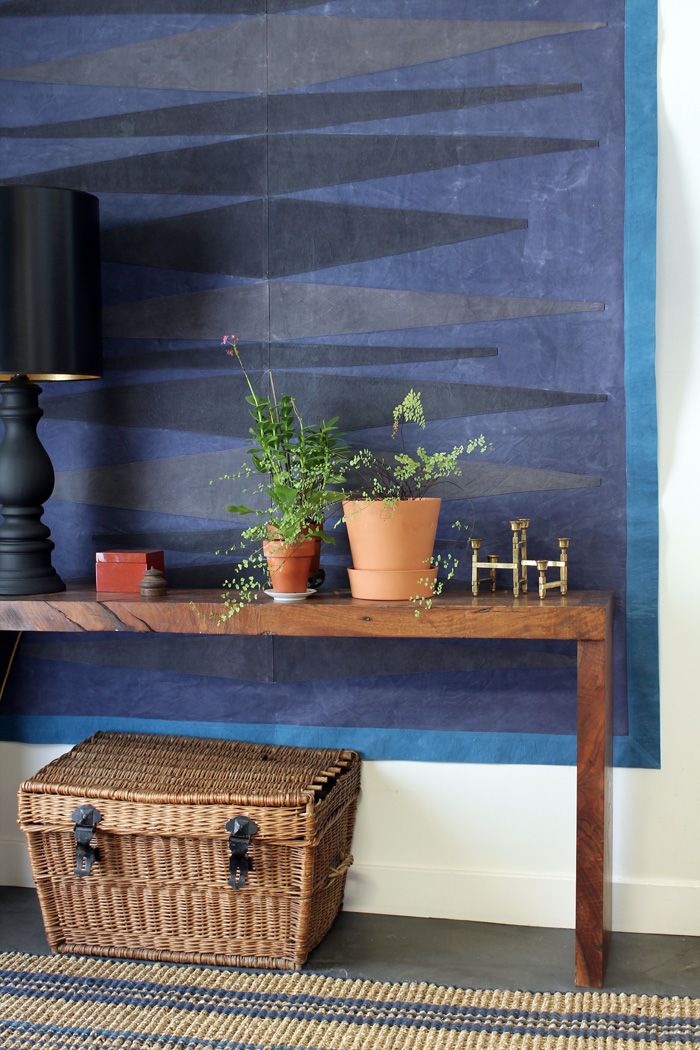 a wooden table topped with plants next to a blue wall